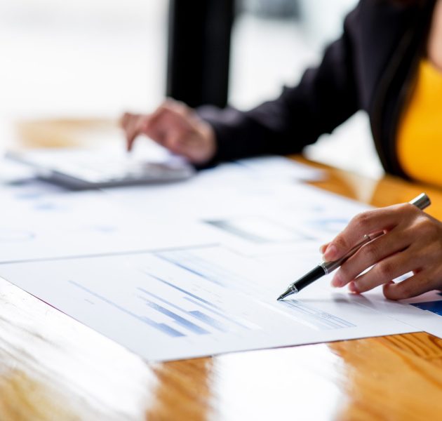 A,Businesswoman,Hand,Using,A,Calculator,With,Documents,Financial,Statistic